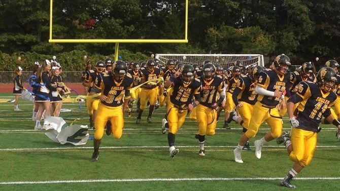 The West Babylon High School Eagles run out onto the...