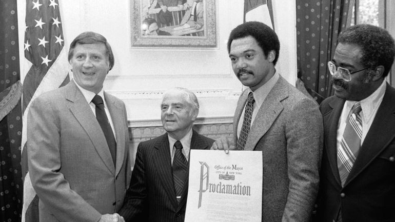 Reggie Jackson, right, holds the proclamation that New York City...