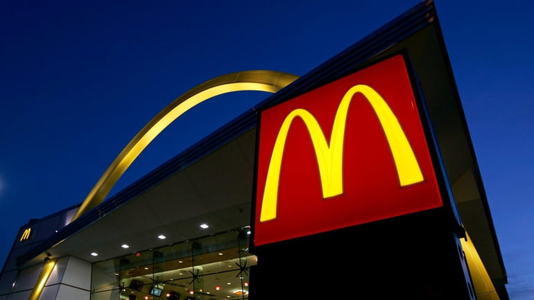 The McDonald's restaurant logo and golden arch is lit up,...