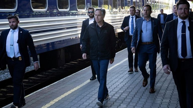 U.S. Secretary of State Antony Blinken, center, walks to board...