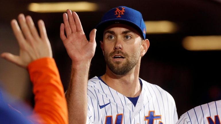 David Peterson of the Mets walks through the dugout after the...