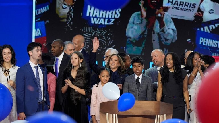 Democratic presidential nominee Vice President Kamala Harris, center, hugs her...