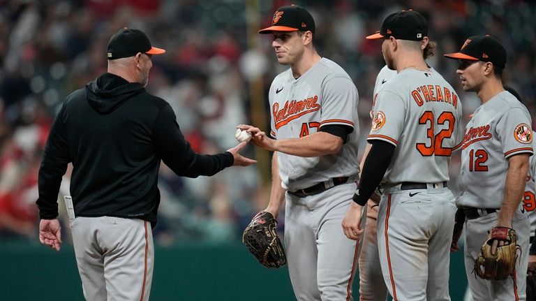 Baltimore Orioles starting pitcher John Means, center, is taken out...