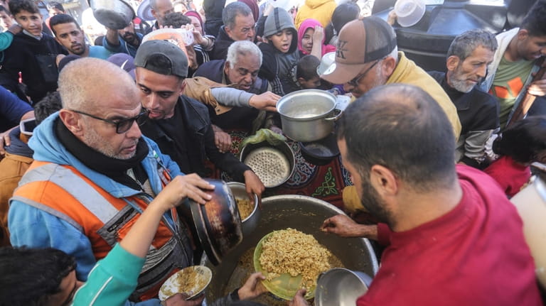 Palestinians line up for food in Rafah, Gaza Strip, Thursday,...