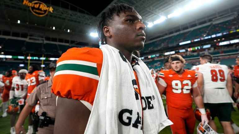 Miami quarterback Cam Ward walks off the field after an...