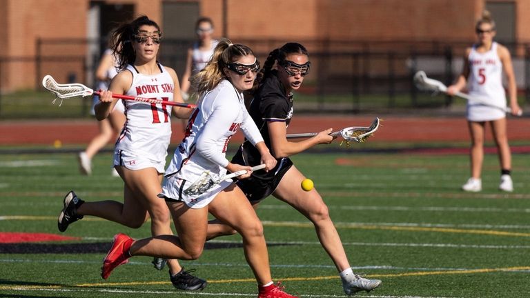 Mount Sinai midfielder Peyton Choma, center, chases down a loose...