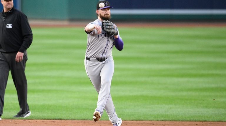 Colorado Rockies second baseman Brendan Rodgers throws to first base...