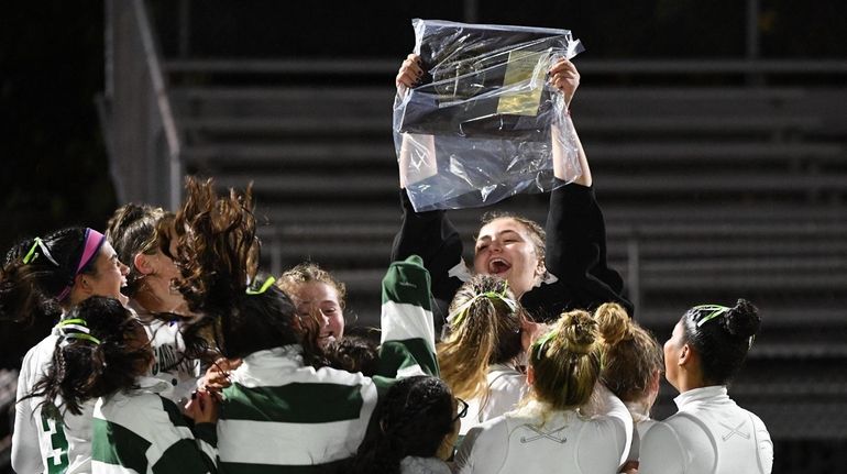 Carle Place players celebrate with their championship plaque after their...