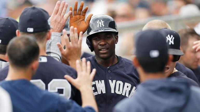 Estevan Florial of the Yankees celebrates with teammates after scoring a...