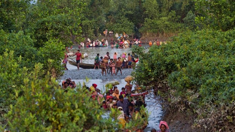 Groups of Rohingya Muslims cross the Naf river at the...