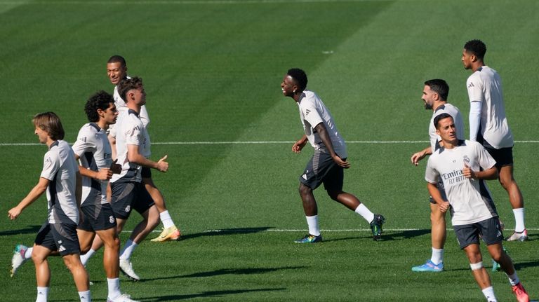 Real Madrid's Vinicius Junior, center, runs during a training session...