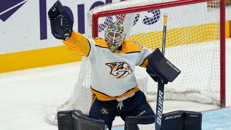 Nashville Predators goaltender Yaroslav Askarov grabs a shot by the...