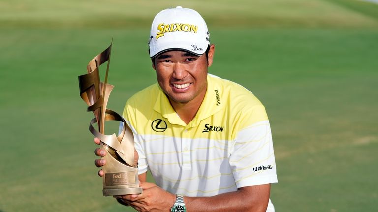 Hideki Matsuyama, of Japan, holds his trophy after winning the...