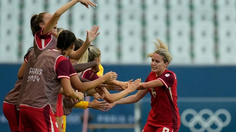 Canada's Cloe Lacasse, right, is congratulated after scoring her side's...