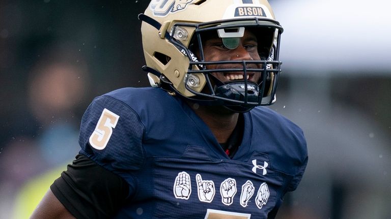 Gallaudet quarterback Brandon Washington runs toward teammates on the bench...