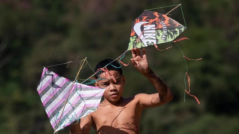 A youth holds kites during a festival in the Turano...