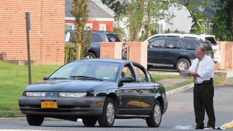 A Suffolk County police homicide detective investigates the scene of...