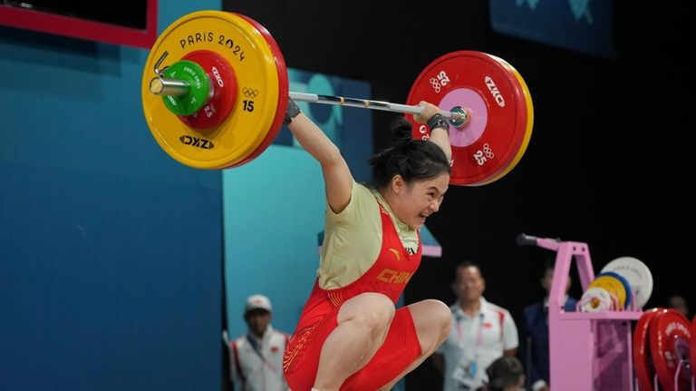 Luo Shifang of China competes during the women's 59kg weightlifting...