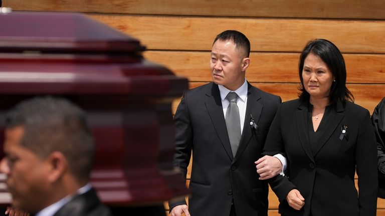 Keiko Fujimori, right, and her brother Kenji stand by as...