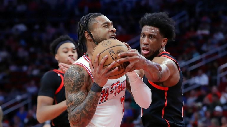 Houston Rockets forward Cam Whitmore, center, drives to the basket...