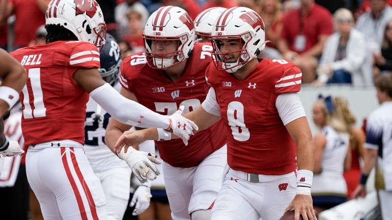 Wisconsin's Tanner Mordecai is congratulated after running for a touchdown...