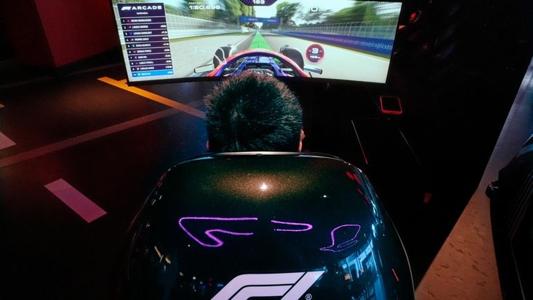 A video game driver races on a simulated track at...