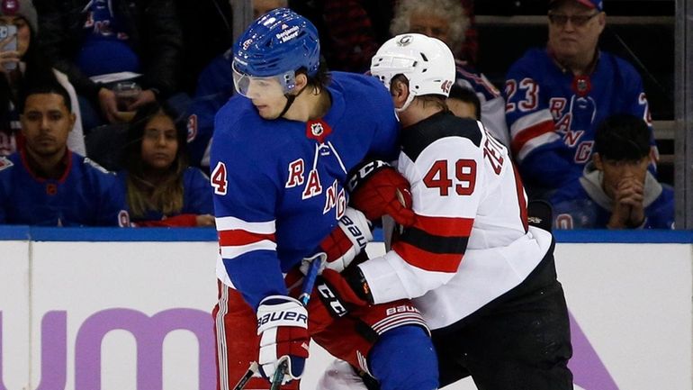 Igor Shesterkin and Braden Schneider of the Rangers defend the net...