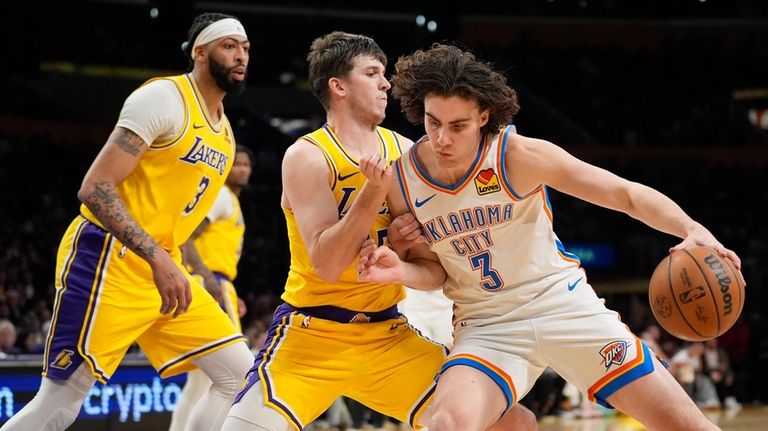 Oklahoma City Thunder guard Josh Giddey, right, right, is defended...