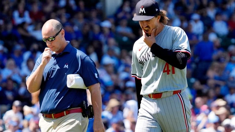 Minnesota Twins starting pitcher Joe Ryan, right, reacts as he...