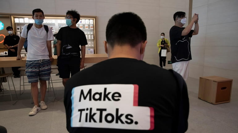 A man wearing a shirt promoting TikTok is seen at...