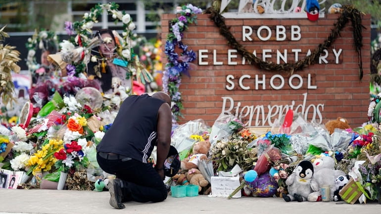 Reggie Daniels pays his respects a memorial at Robb Elementary...