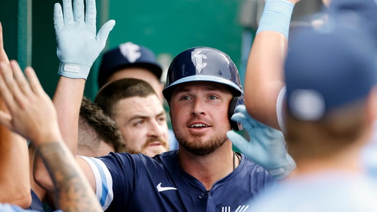 Kansas City Royals' Hunter Renfroe is congratulated in the dugout...