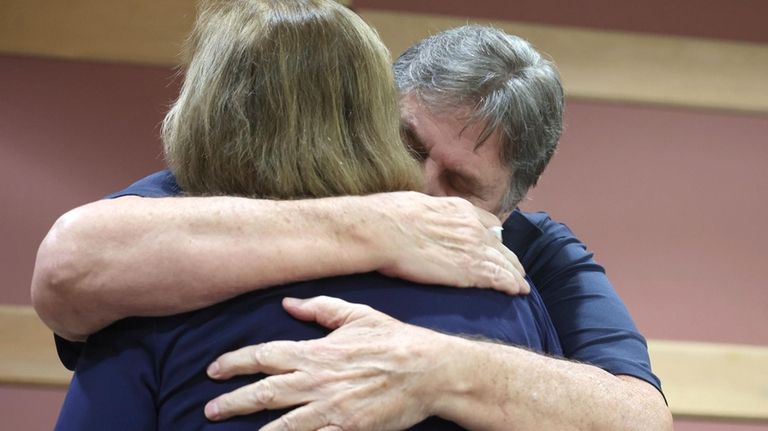 Joe and Rae Dowling comfort each other during a hearing...