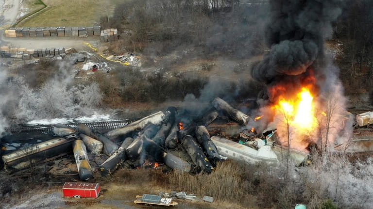 Portions of a Norfolk Southern freight train that derailed the...