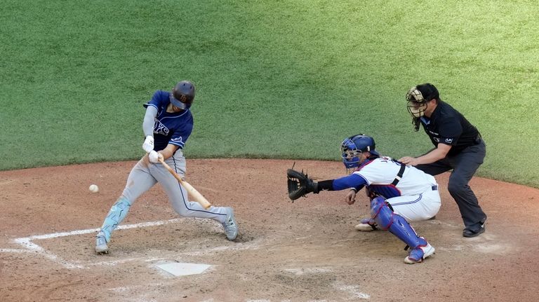 Tampa Bay Rays' Brandon Lowe, left, hits an RBI single...