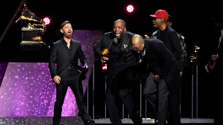 Killer Mike , center, celebrates as he accepts the award...