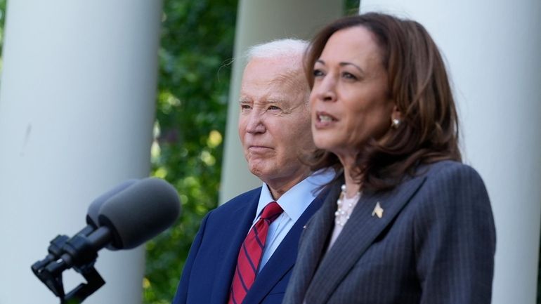 President Joe Biden listens as Vice President Kamala Harris speaks...