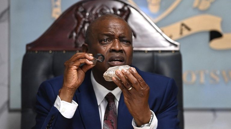 Botswana's President Mokgweetsi Masisi holds the 2,492-carat diamond that was...