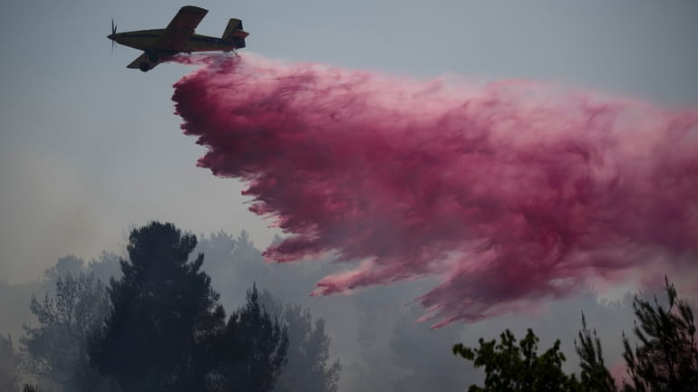 A plane uses a fire retardant to extinguish a fire...