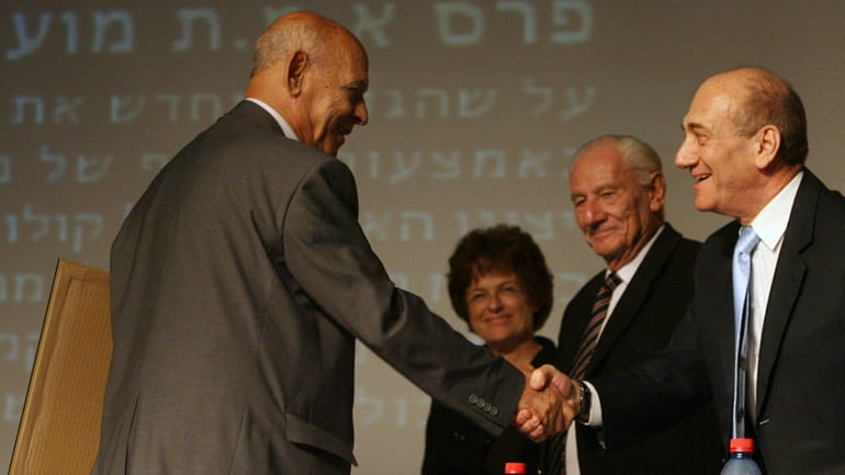 Iraqi-born Israeli author Sami Michael, left, is congratulated by Israeli...