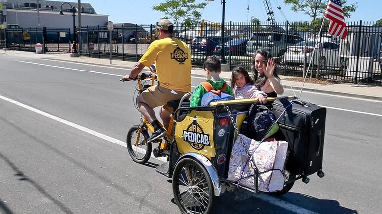 Justin Galbraith, owner of Fire Island Pedicab, transports Maddy Novich...