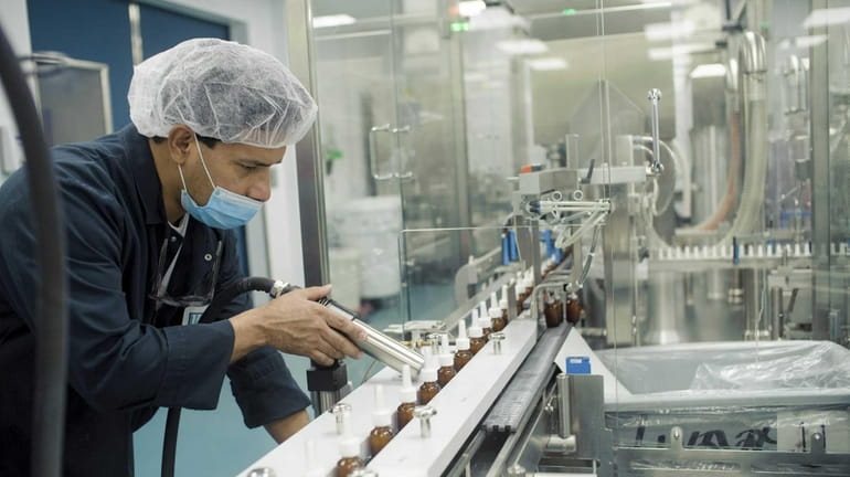 A worker prepares a production line at Hi-Tech Pharmacal plant...