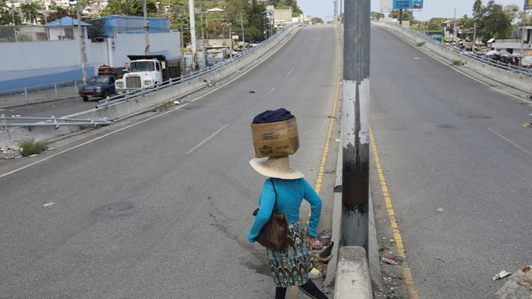 A street vendor crosses a street that is empty due...