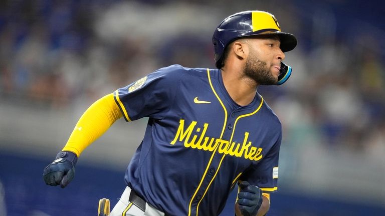 Milwaukee Brewers' Jackson Chourio runs toward first as he flies...