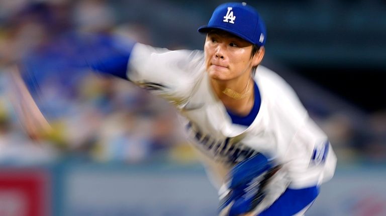 Los Angeles Dodgers starting pitcher Yoshinobu Yamamoto throws to the...