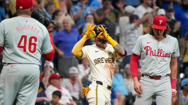 Milwaukee Brewers' Joey Ortiz reacts after hitting an RBI triple...