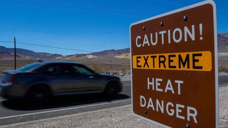 A sign stands warning of extreme heat Tuesday, July 11,...