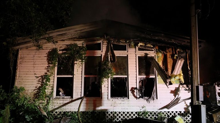 Firefighters work the scene of a deadly house fire early...