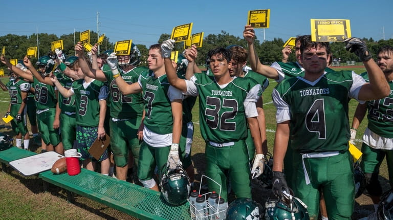 Members of Harborfields High School's varsity football team stand together...