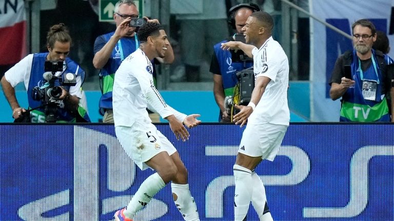 Real Madrid's Kylian Mbappe celebrates with Jude Bellingham, left, after...